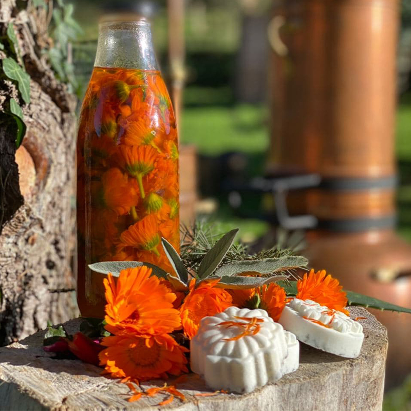 Jabones naturales. Blancos, forma circular y relieves de referencia natural. con botella de aceite esencial.